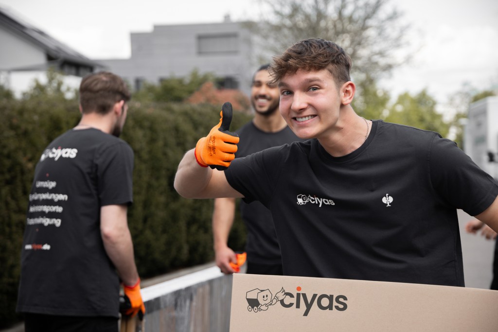 Strahlender Mitarbeiter der Ciyas GmbH bei einem Firmenumzug in Nürtingen
