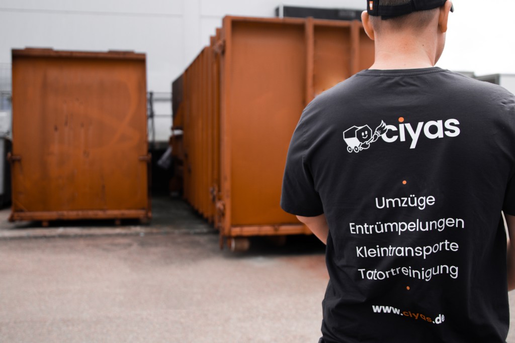 Man sieht den Rücken eines jungen Mitarbeiters der Ciyas GmbH wie er auf dem Entsorgungshof steht.