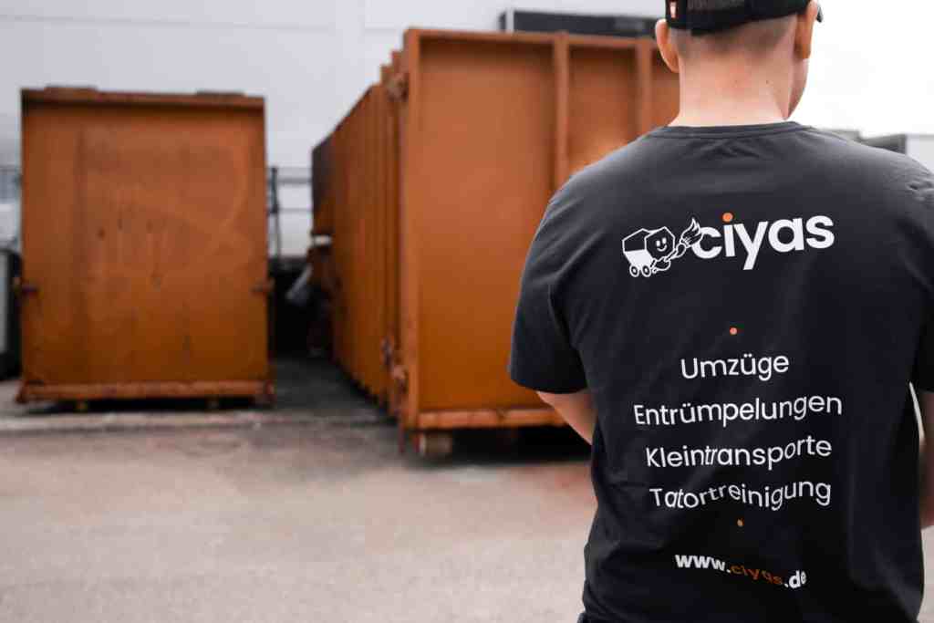Man sieht den Rücken eines jungen Mitarbeiters der Ciyas GmbH wie er auf dem Entsorgungshof steht.